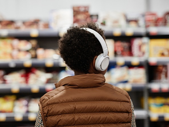 young man shopping in a supermarket wearing headphones